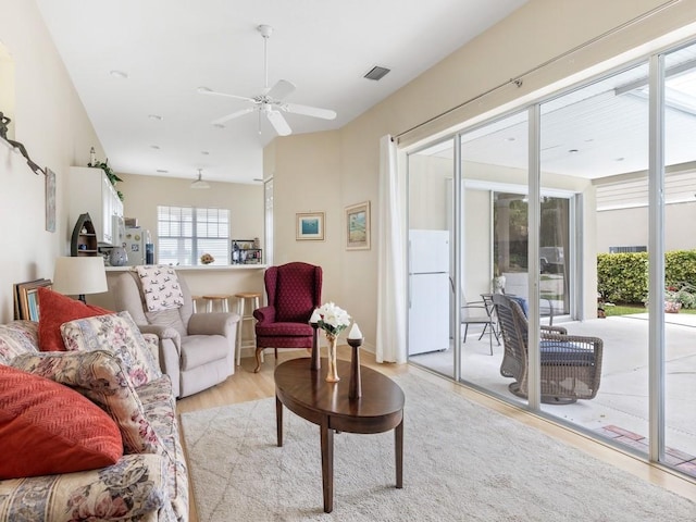 living room with light wood-type flooring and ceiling fan