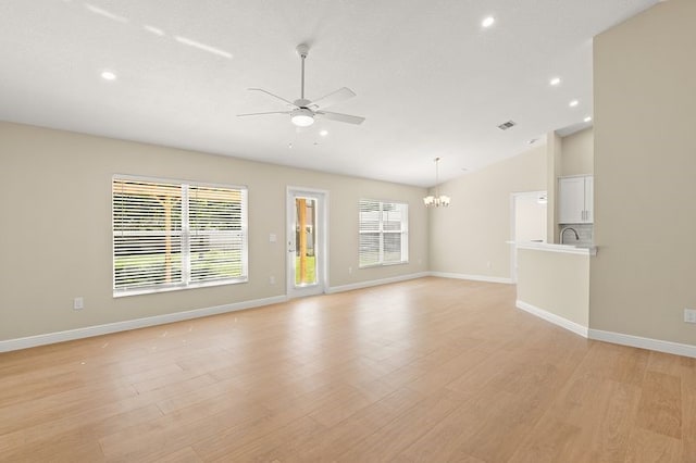 1590 Polynesian Ln, Sebastian, FL 32958 - unfurnished living room featuring ceiling fan, vaulted ceiling, a chandelier, recessed lighting, and light wood-type flooring