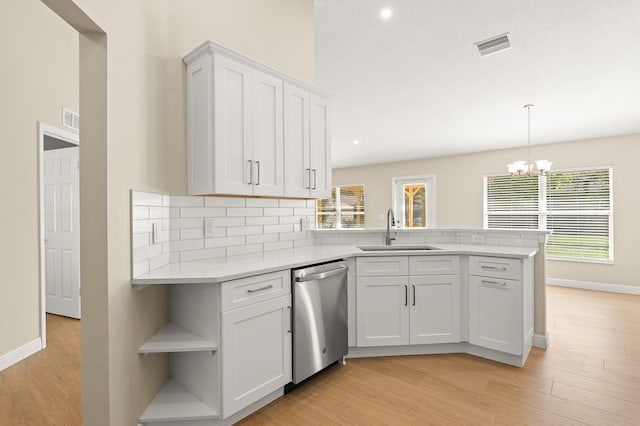 1590 Polynesian Ln, Sebastian, FL 32958 - kitchen with dishwasher, a peninsula, light wood-style flooring, a chandelier, and open shelves