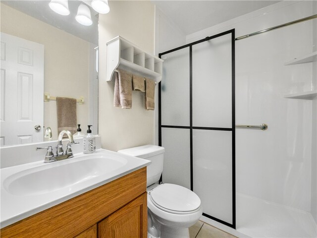 bathroom with toilet, vanity, tile patterned flooring, and a shower with door