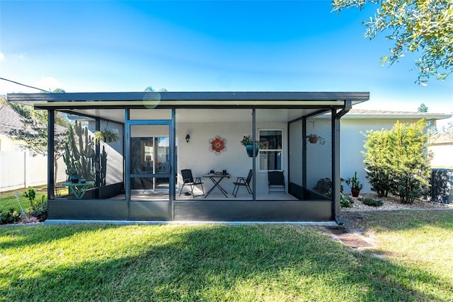 back of house with a lawn and a sunroom