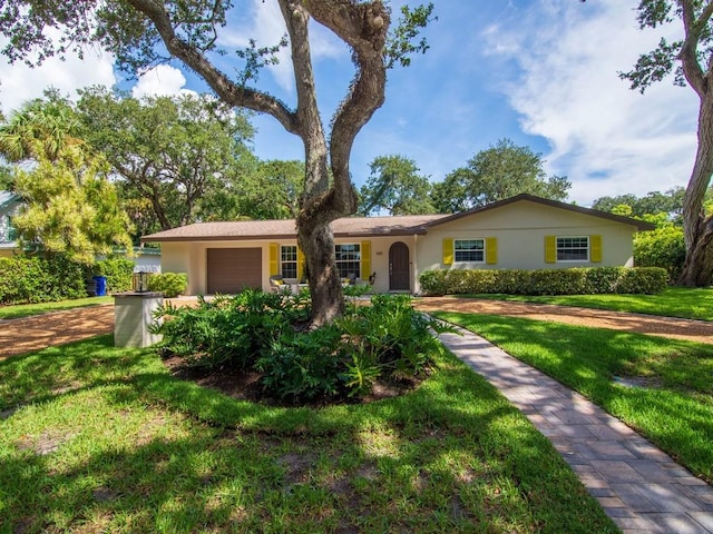 single story home featuring a garage and a front lawn