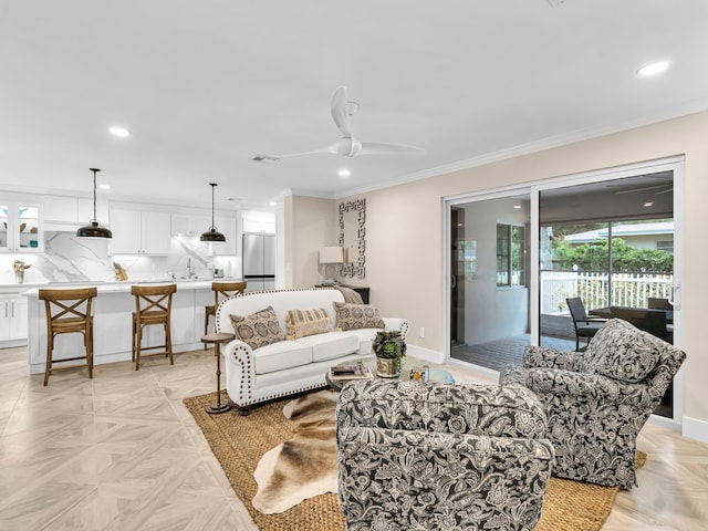 living room featuring visible vents, baseboards, a ceiling fan, ornamental molding, and recessed lighting