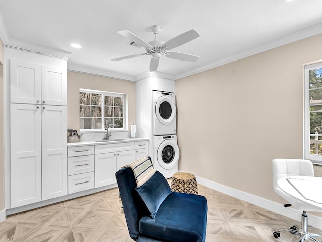 laundry area featuring stacked washer and dryer, sink, ceiling fan, ornamental molding, and light parquet flooring