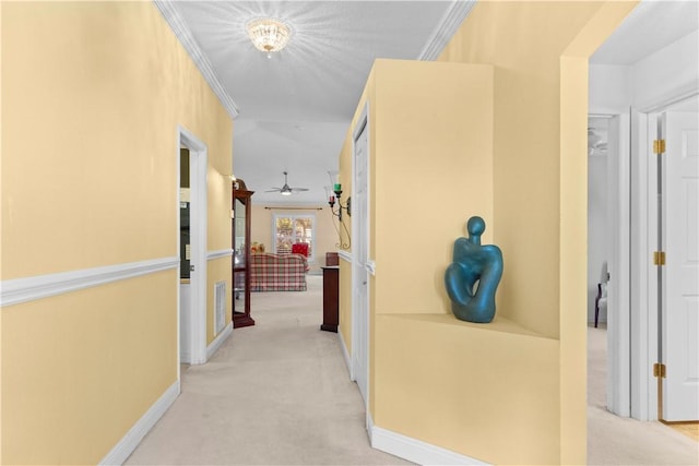 hall with crown molding and light carpet