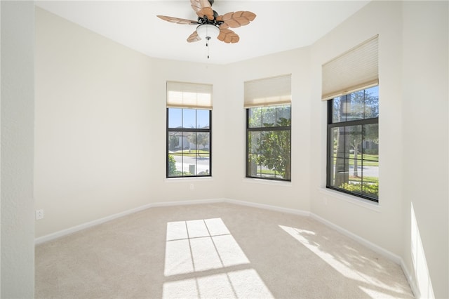 unfurnished room featuring light carpet, ceiling fan, and baseboards