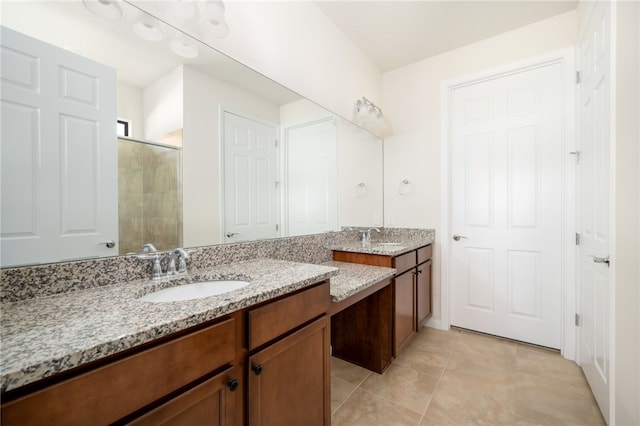 full bathroom featuring double vanity, a stall shower, tile patterned flooring, and a sink