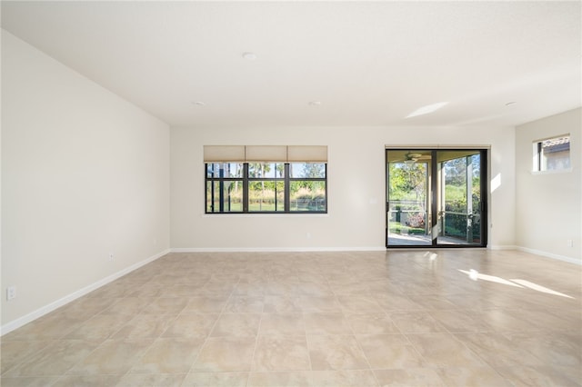 empty room with a wealth of natural light and baseboards