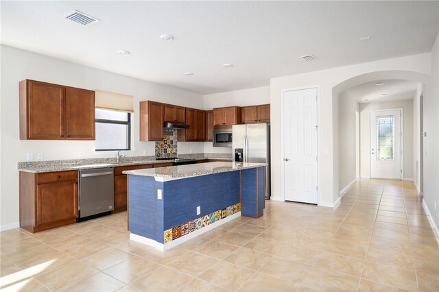 kitchen featuring light tile patterned floors, sink, backsplash, a kitchen island, and stainless steel electric stove