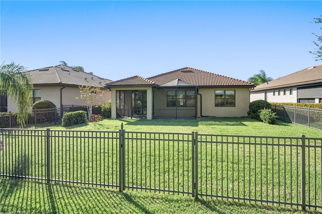 view of front of house with stucco siding, a fenced backyard, a front yard, and a tiled roof