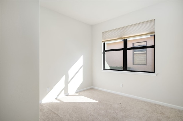 empty room with light colored carpet and baseboards