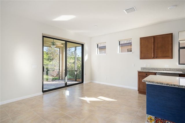 kitchen with light stone counters, visible vents, baseboards, and light tile patterned flooring