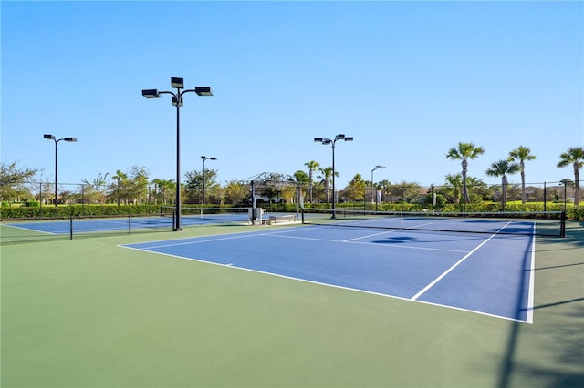 view of tennis court featuring fence