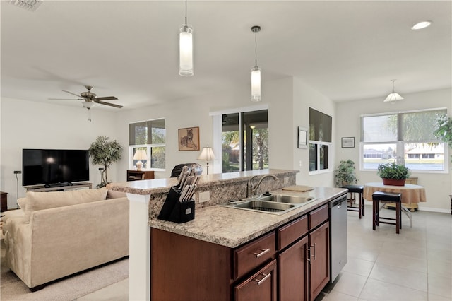 kitchen with pendant lighting, dishwasher, an island with sink, sink, and ceiling fan