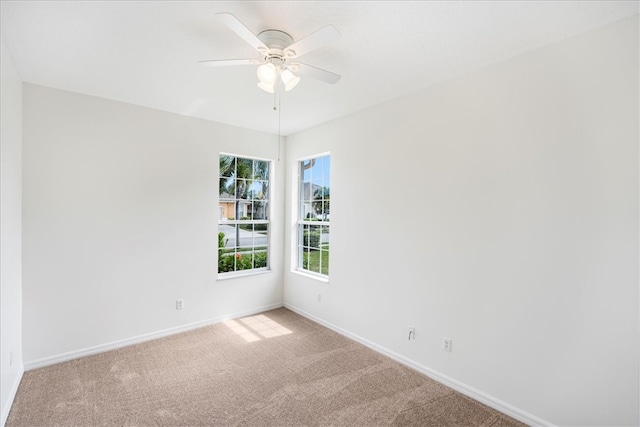 spare room with ceiling fan and light colored carpet