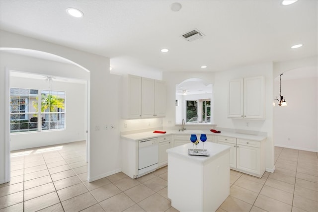 kitchen with white cabinets, plenty of natural light, a kitchen island, and dishwasher