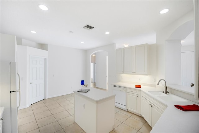 kitchen featuring light tile patterned flooring, sink, white appliances, a center island, and white cabinets