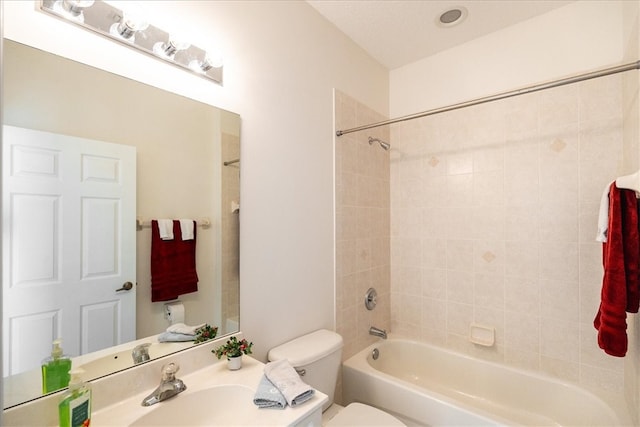 full bathroom featuring tiled shower / bath, sink, and toilet