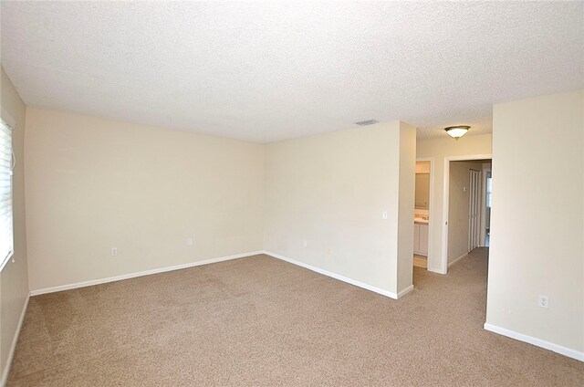 carpeted empty room with a textured ceiling