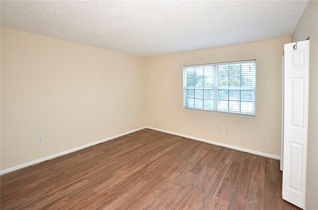 unfurnished room featuring a textured ceiling and hardwood / wood-style flooring