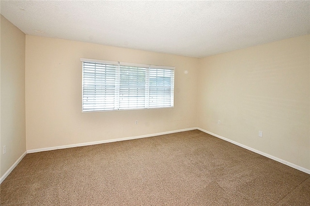 carpeted spare room with a textured ceiling