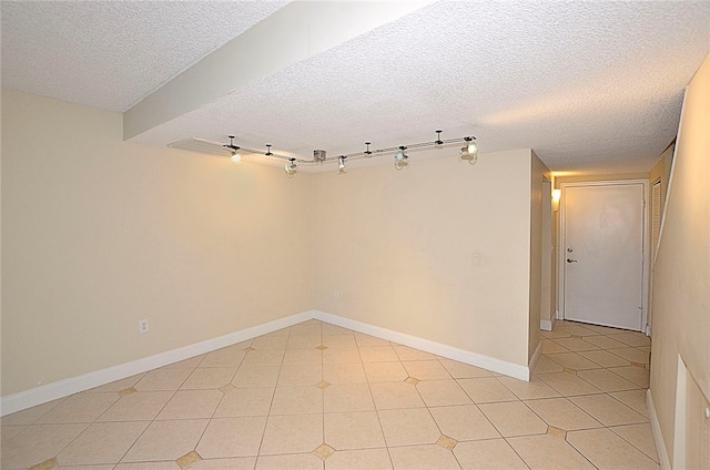 spare room with light tile patterned flooring and a textured ceiling