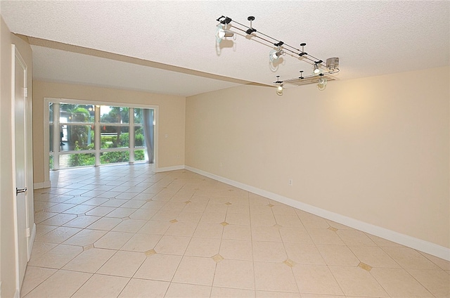 tiled empty room with a textured ceiling