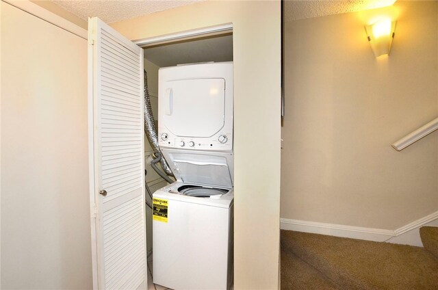 laundry area with a textured ceiling and stacked washer / dryer