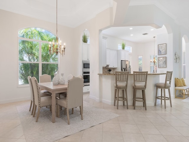 tiled dining room with a notable chandelier and crown molding