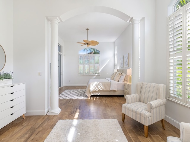 bedroom with decorative columns, ceiling fan, and light hardwood / wood-style floors