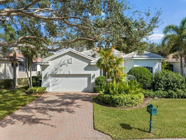 view of front of property featuring a front yard and a garage