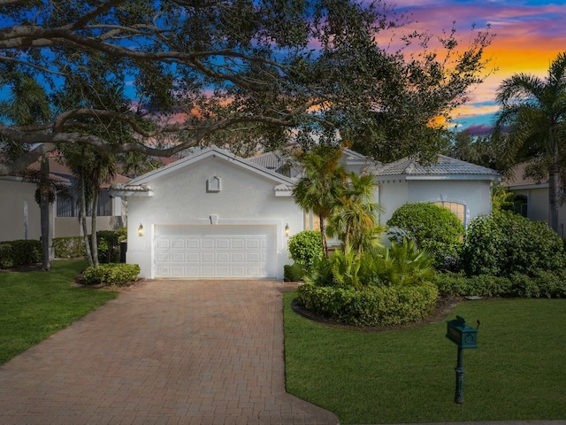 view of front of property featuring a garage and a lawn