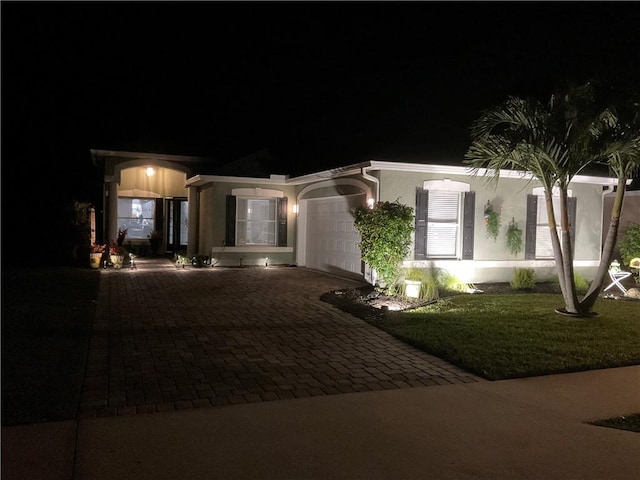 view of front of property with a garage and a yard