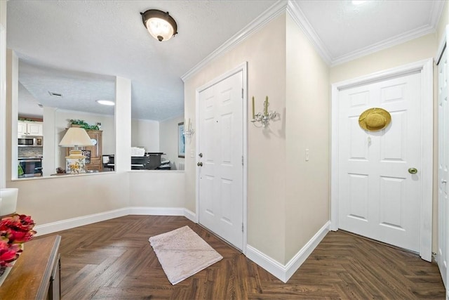 foyer entrance featuring baseboards, a textured ceiling, and crown molding