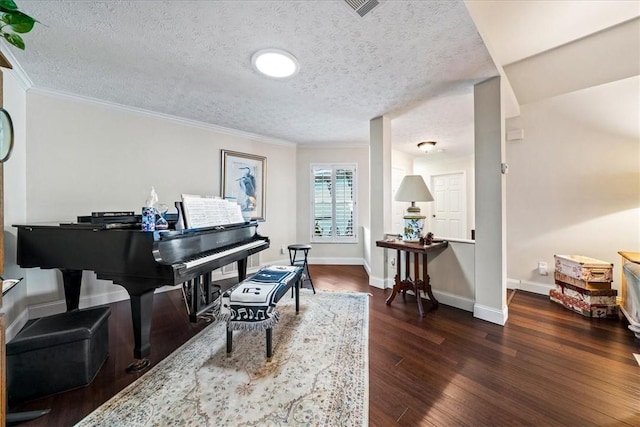 living area featuring visible vents, wood finished floors, baseboards, and a textured ceiling