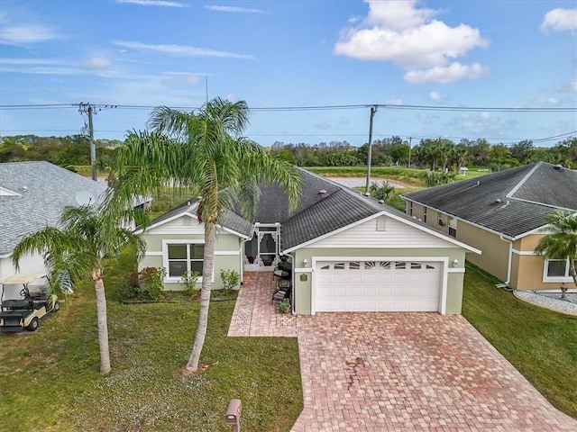 ranch-style house with a garage, decorative driveway, and a front yard