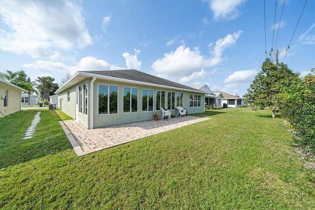 back of house featuring a patio area, a lawn, and stucco siding