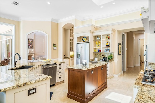kitchen with appliances with stainless steel finishes, a sink, a large island, ornamental molding, and open shelves