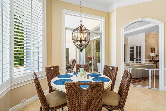 tiled dining area featuring ornamental molding and an inviting chandelier