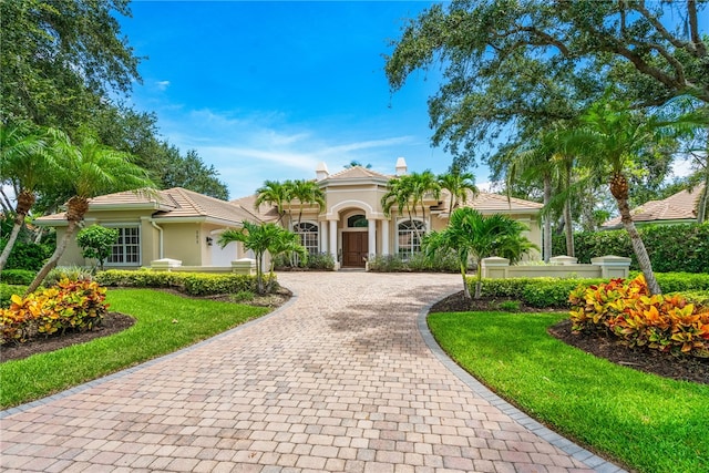 mediterranean / spanish home featuring a front yard