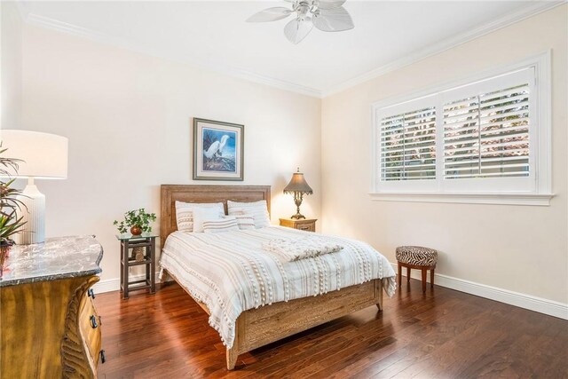 bedroom featuring crown molding, baseboards, wood finished floors, and a ceiling fan