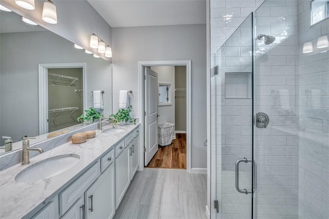 1359 Haven Cir, Vero Beach, FL 32960 - bathroom with double vanity, a spacious closet, a stall shower, and baseboards
