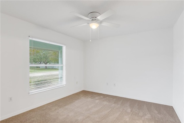 carpeted spare room with ceiling fan