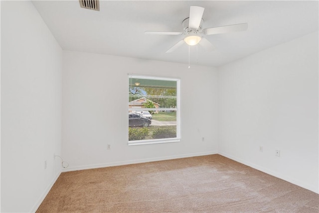 empty room with ceiling fan and light carpet