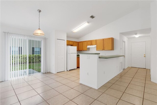2500 89th Ave, Vero Beach, FL 32966 - kitchen with freestanding refrigerator, a peninsula, lofted ceiling, under cabinet range hood, and hanging light fixtures