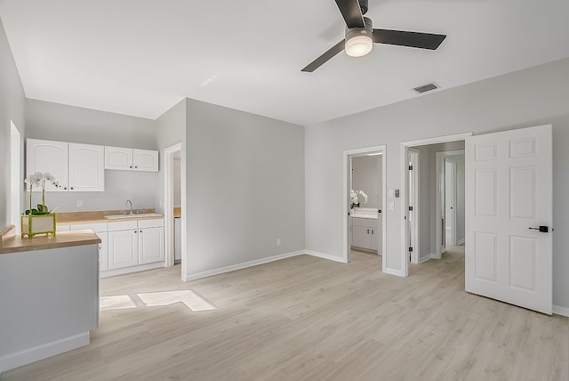 interior space with light hardwood / wood-style flooring, sink, and ceiling fan