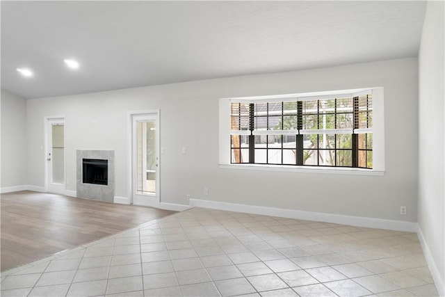 unfurnished living room featuring light tile patterned floors and a tiled fireplace