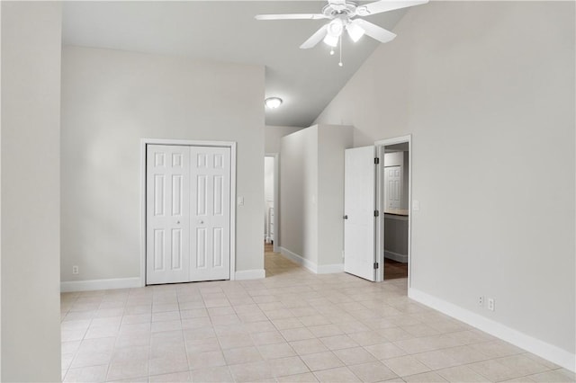 unfurnished bedroom featuring ceiling fan, light tile patterned flooring, a closet, and high vaulted ceiling