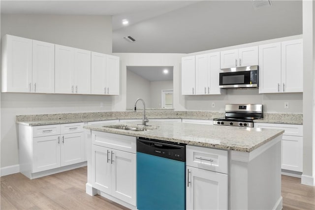 kitchen featuring stainless steel appliances, lofted ceiling, white cabinetry, and sink