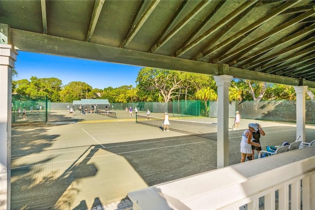 view of community with fence and a tennis court